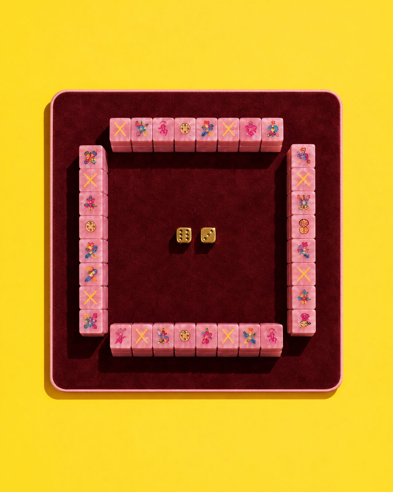 An oxblood mat with four walls of pink tiles, from above, on yellow