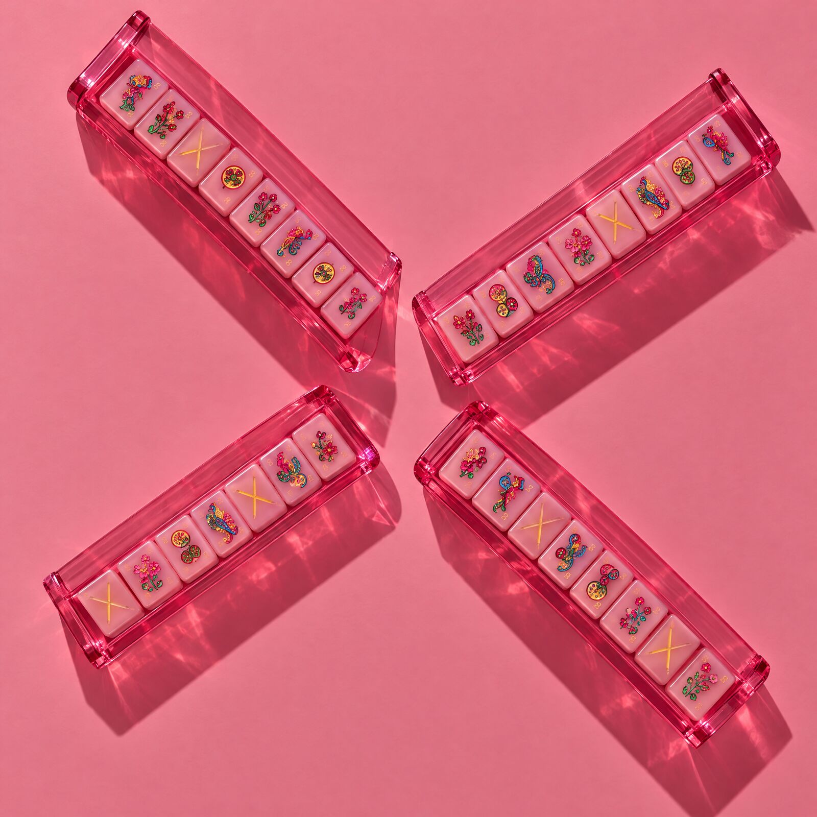 Four pink acrylic racks arranged as a pinwheel on pink