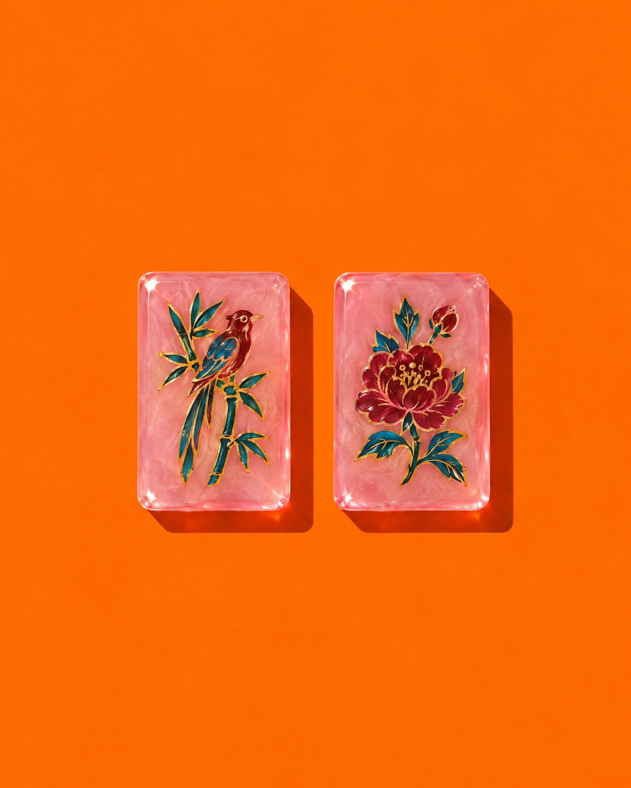 Two hand-painted pink tiles, a bird and a peony, on orange
